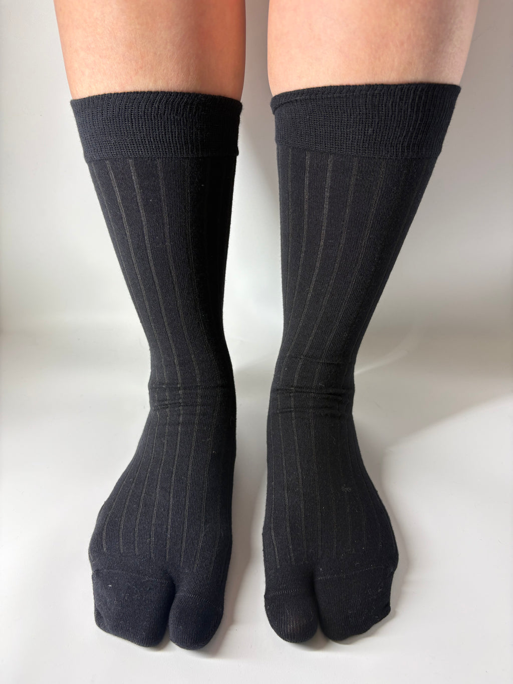 Black ribbed crew tabi socks worn on a white background