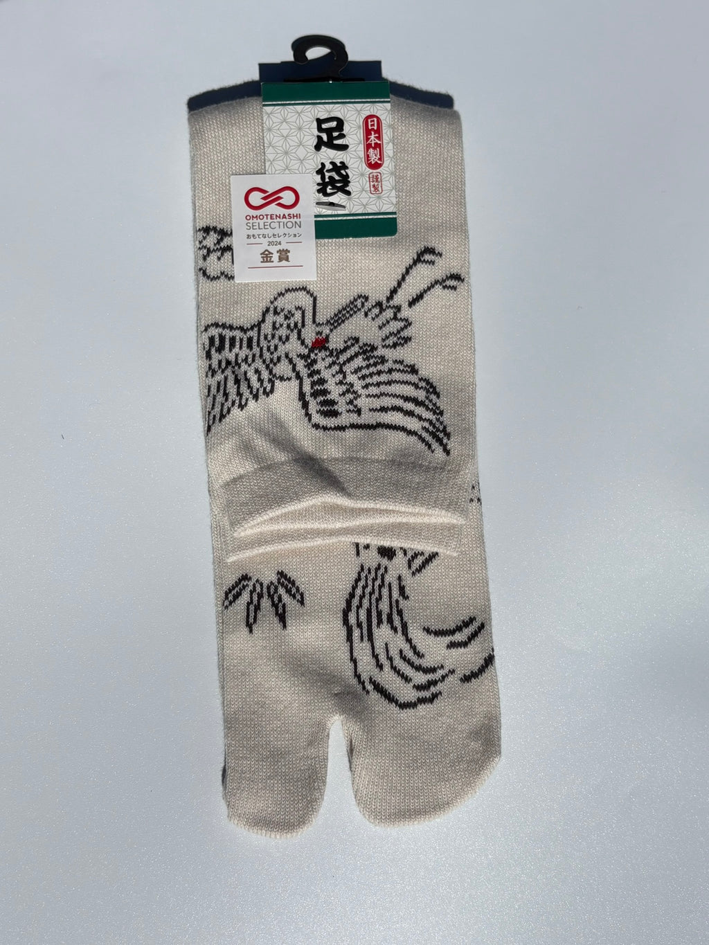 Cream Tabi sock with crane, turtle and leaf design on a light gray background