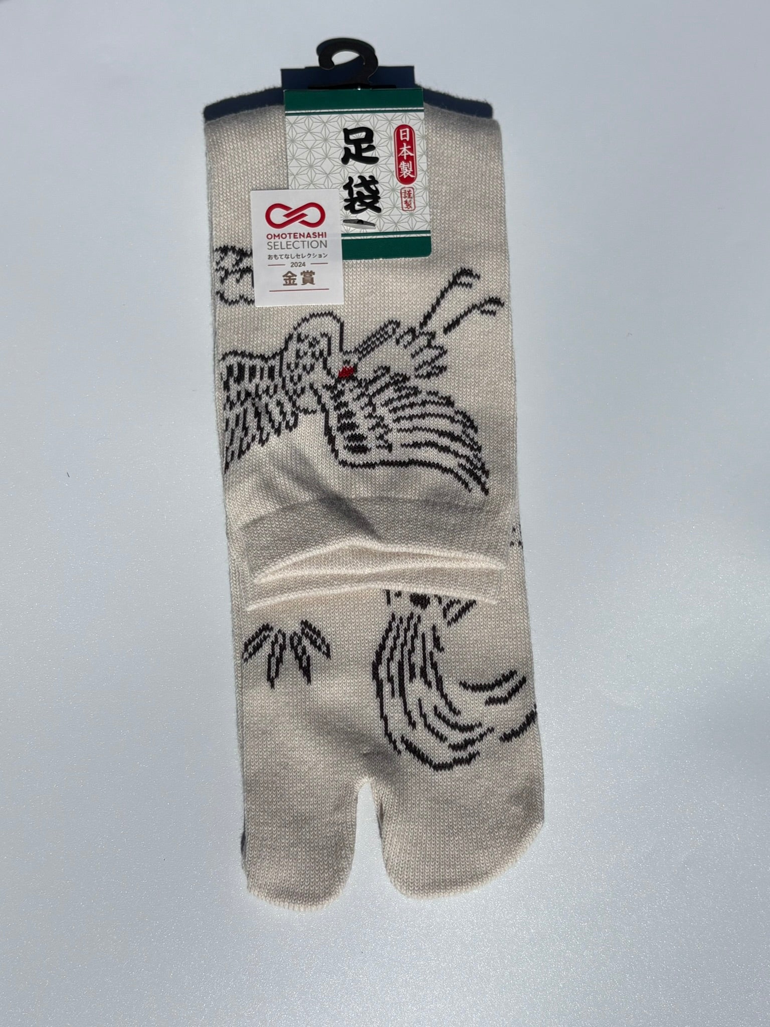 Cream Tabi sock with crane, turtle and leaf design on a light gray background