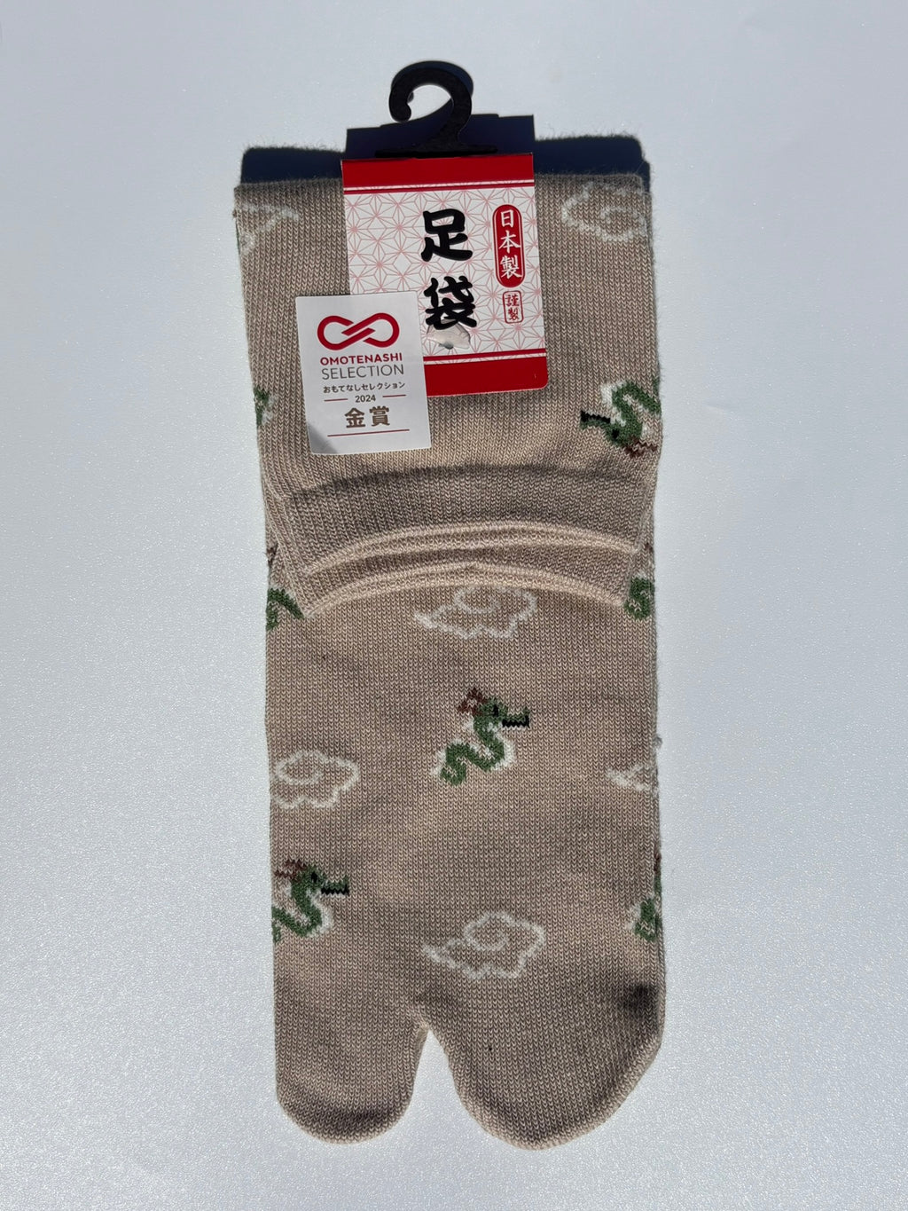pair of beige dragon and clouds print tabi socks made in japan premium cotton quality lay flat on white background
