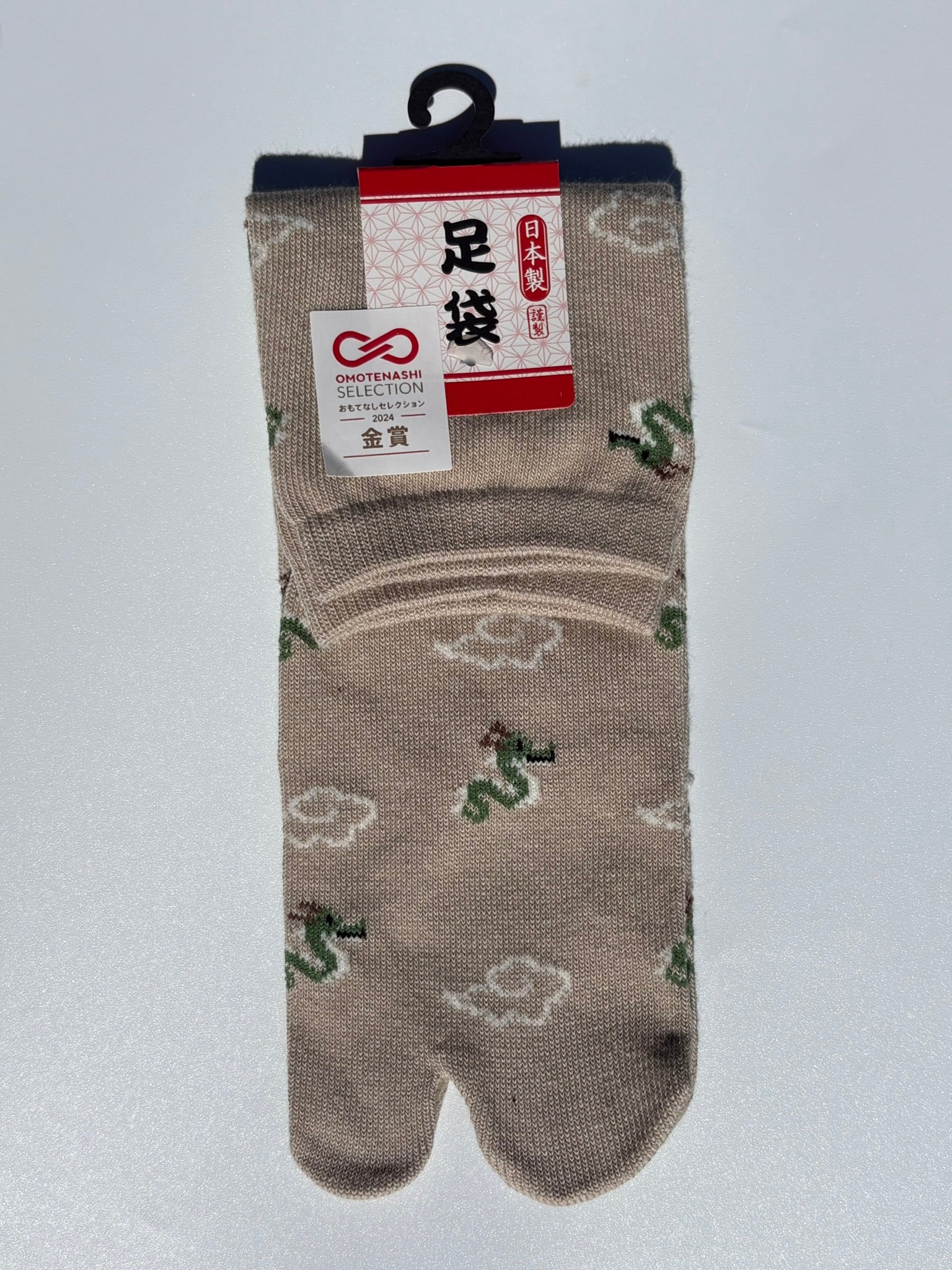 pair of beige dragon and clouds print tabi socks made in japan premium cotton quality lay flat on white background