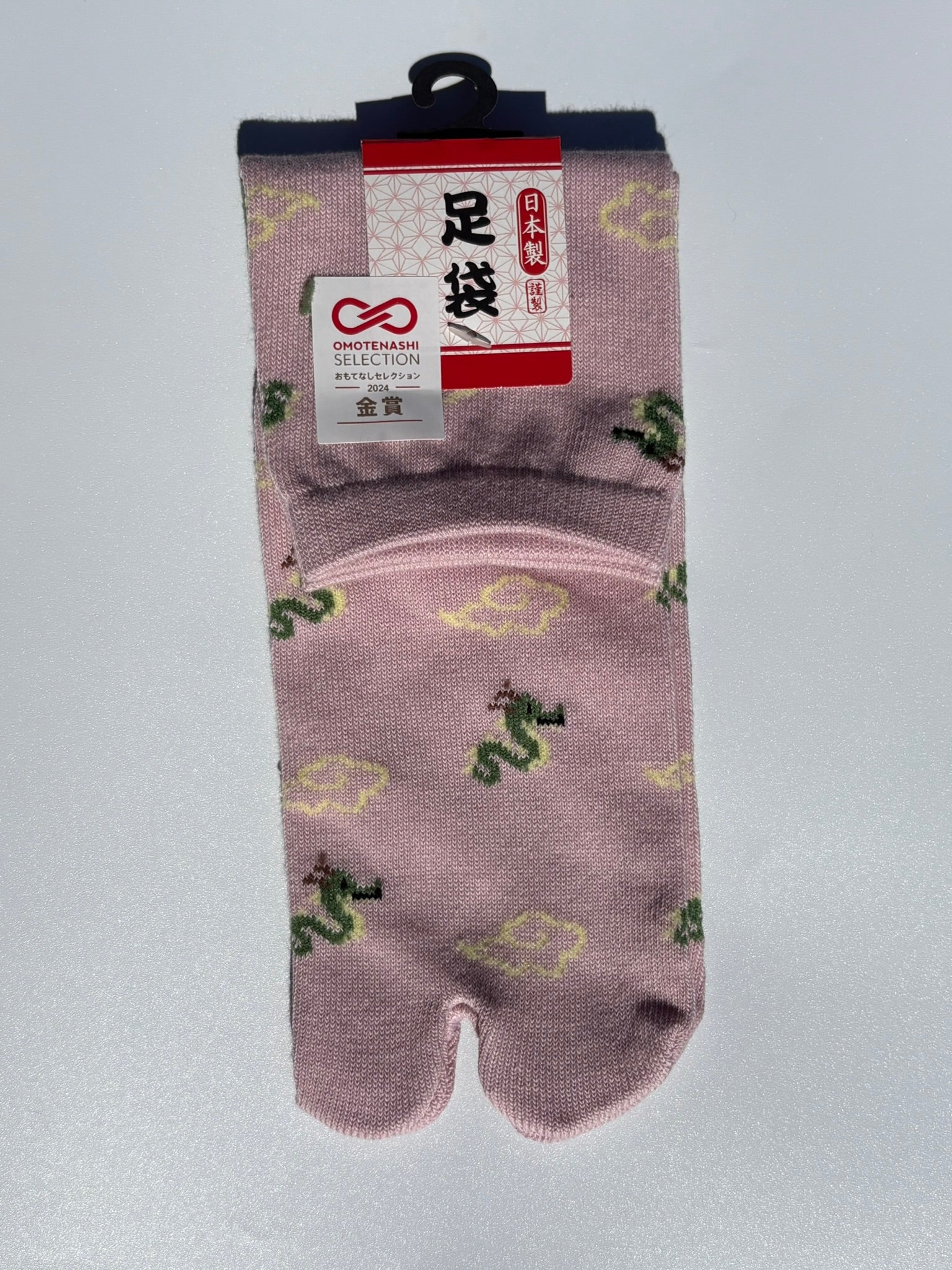 pink pair of beige dragon and clouds print tabi socks made in japan premium cotton quality lay flat on white background
