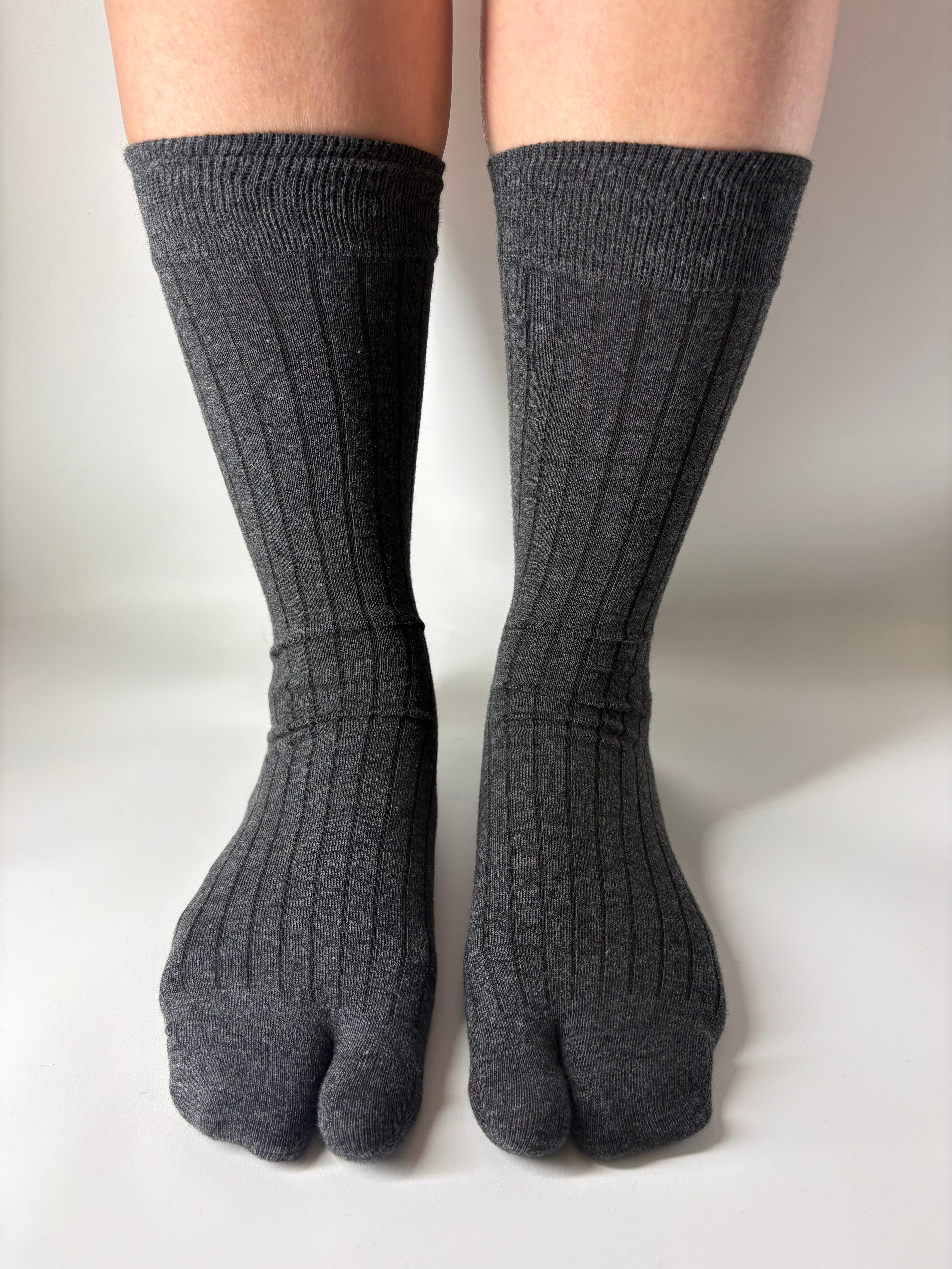 Gray tabi socks worn on a white background