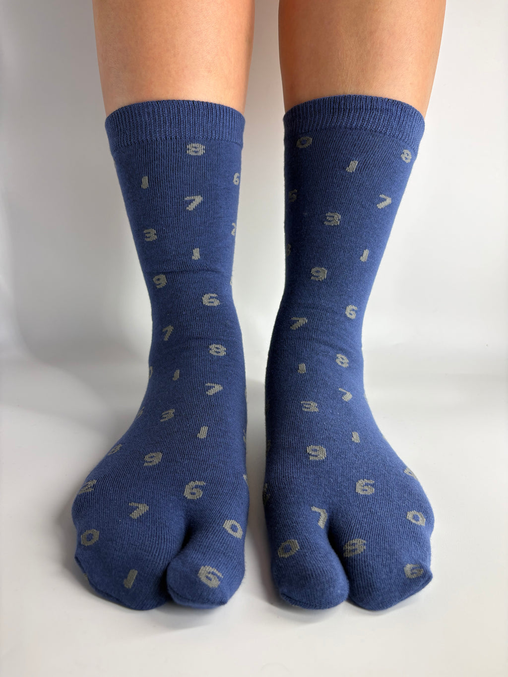 Denim blue crew length tabi socks with grey number print on, standing on a white background