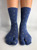 Denim blue crew length tabi socks with grey number print on, standing on a white background