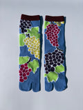 Pair of blue tabi socks with fruit pattern on a light blue background