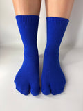 Blue toe socks worn on a white background