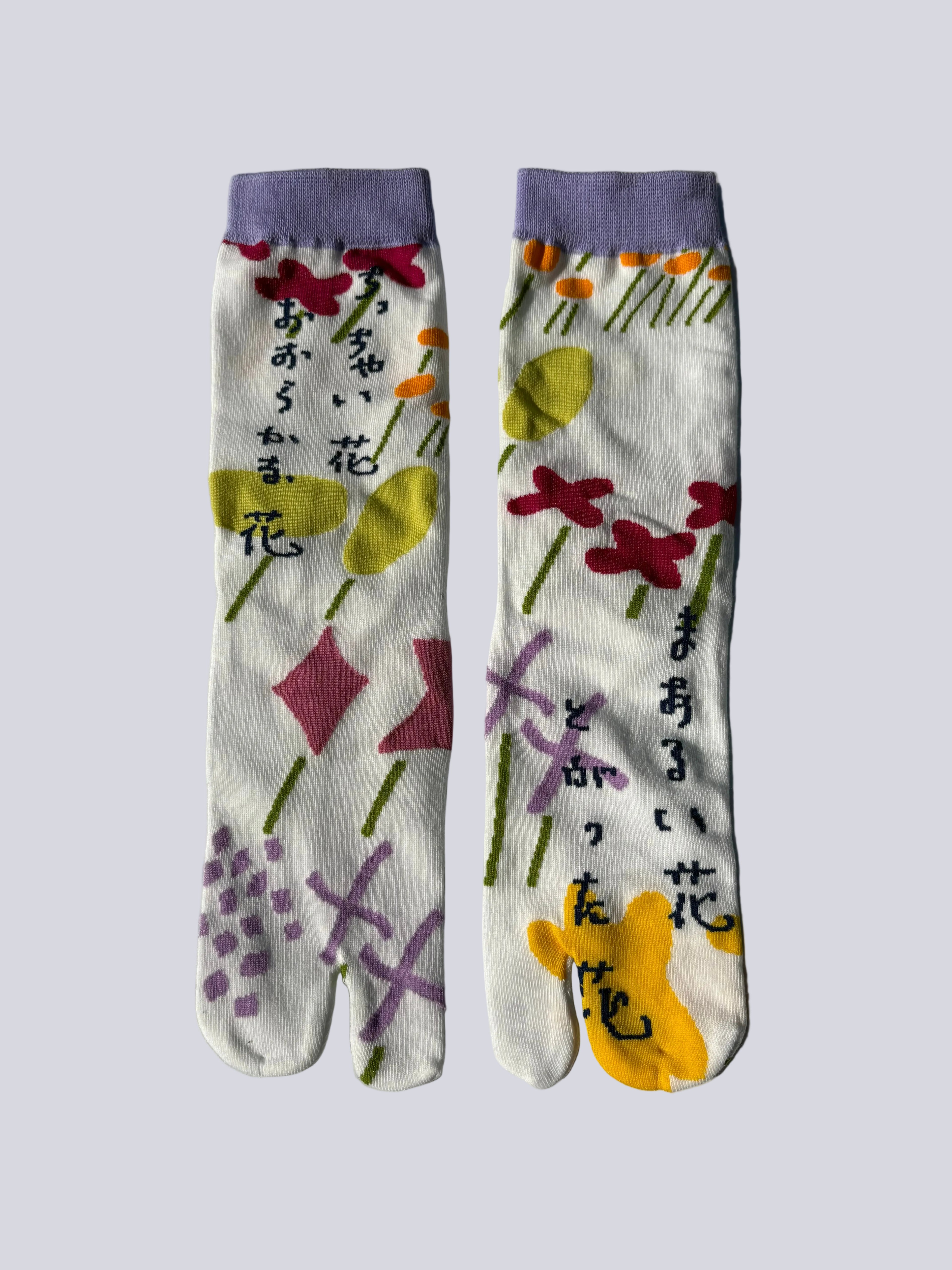 White tabi split-toe socks with pastel abstract floral print in different shades of green red lilac and yellow and purple, purple cuff — Japanese patterned tabi socks
