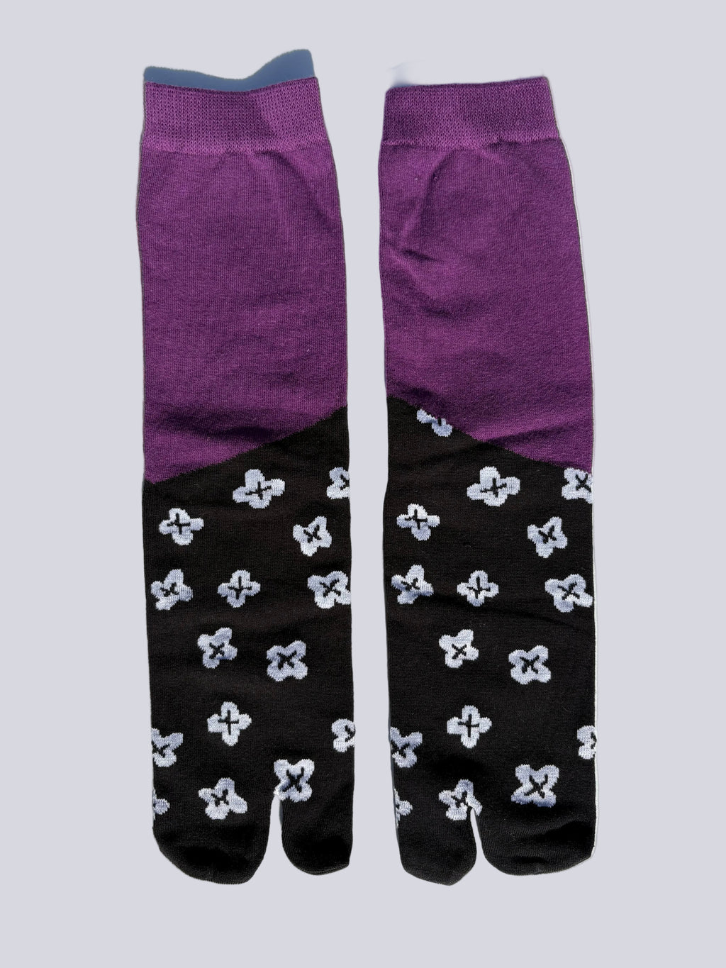 Colour-block tabi split-toe socks with solid purple upper and black lower with white floral motif print — Japanese fashion tabi socks