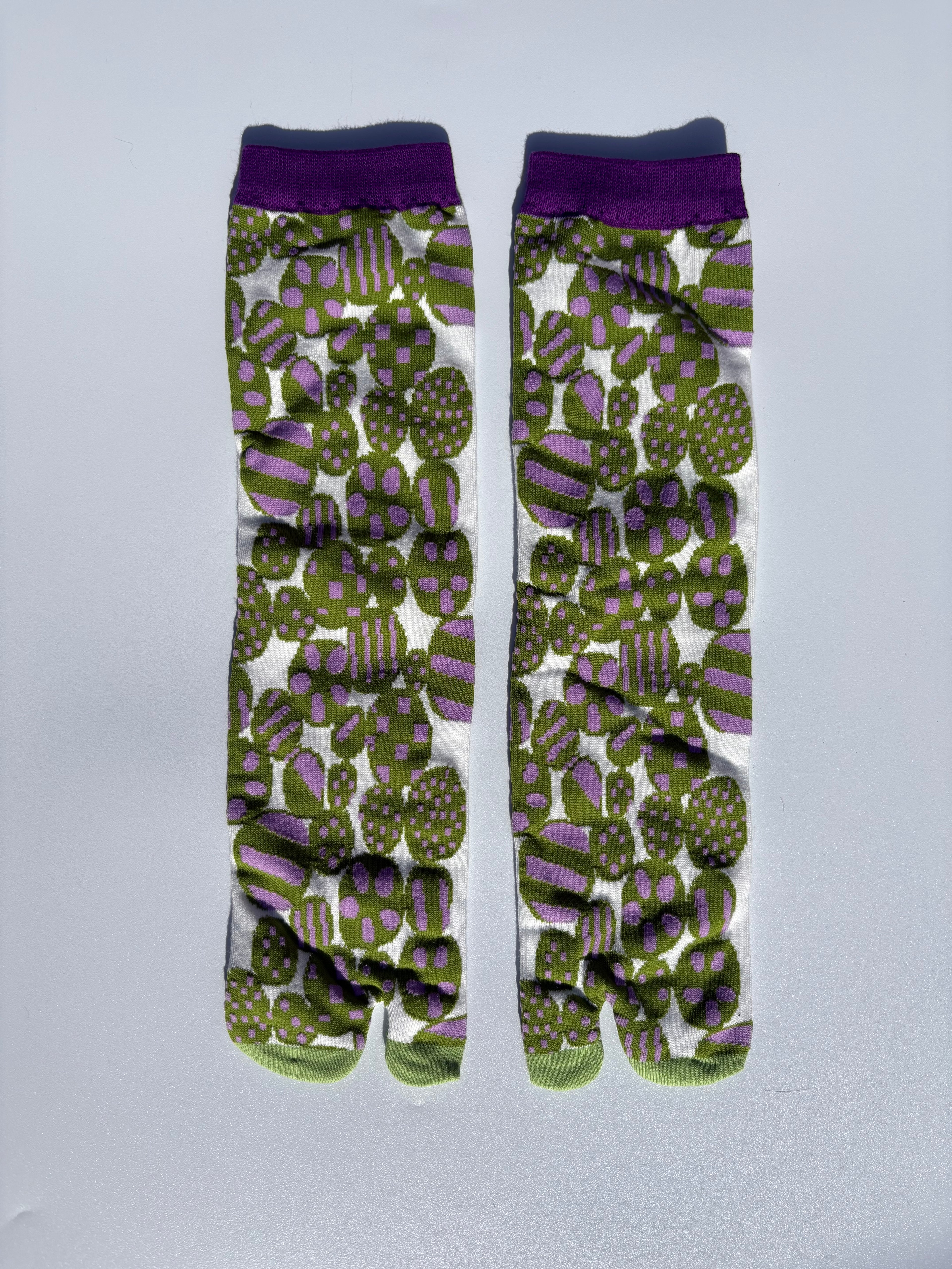 White tabi split-toe socks with bold abstract floral print in olive green and purple, purple cuff — Japanese patterned tabi socks of cotton material
