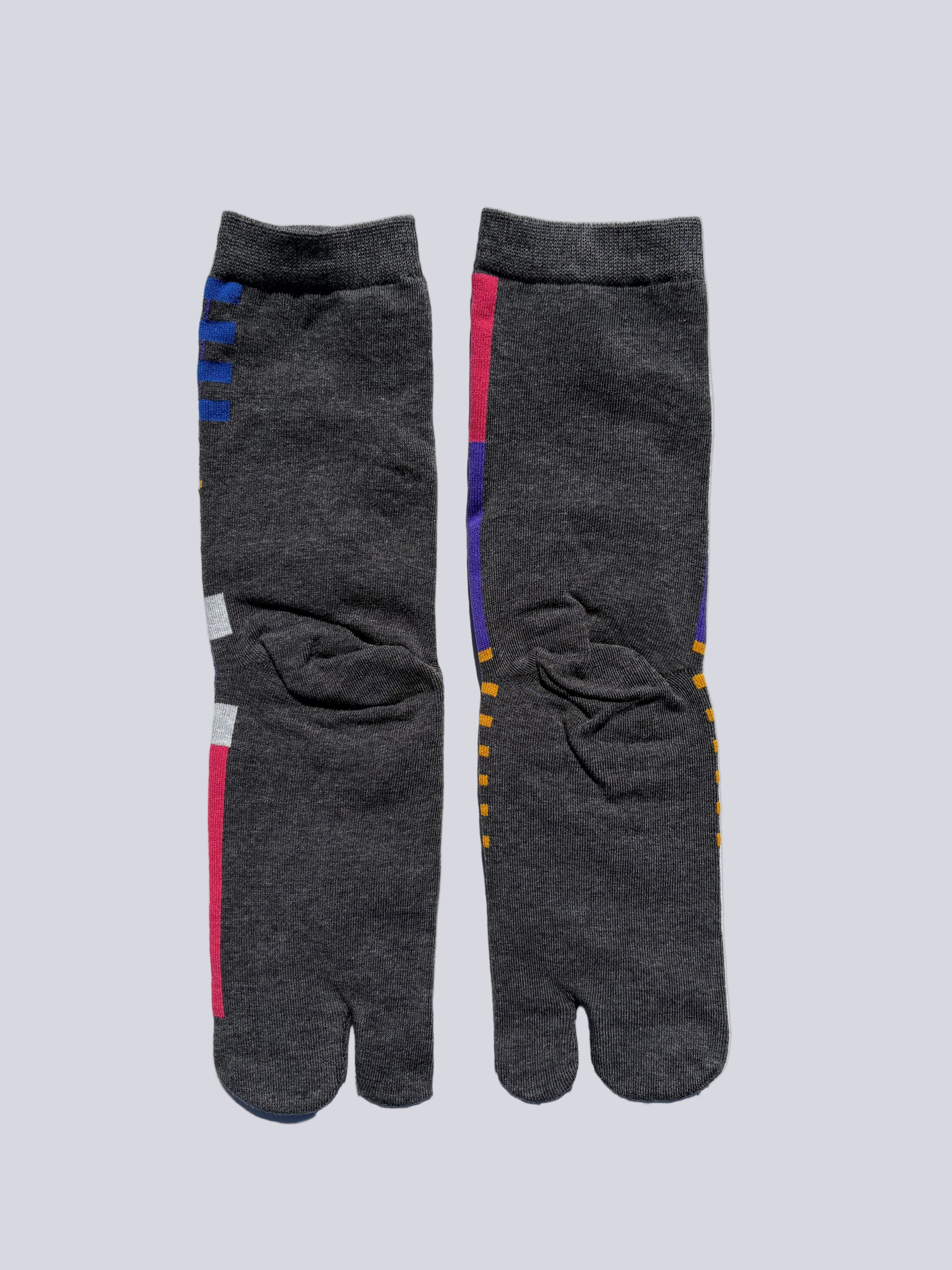 Pair of gray tabi socks with colorful accents on a light gray background