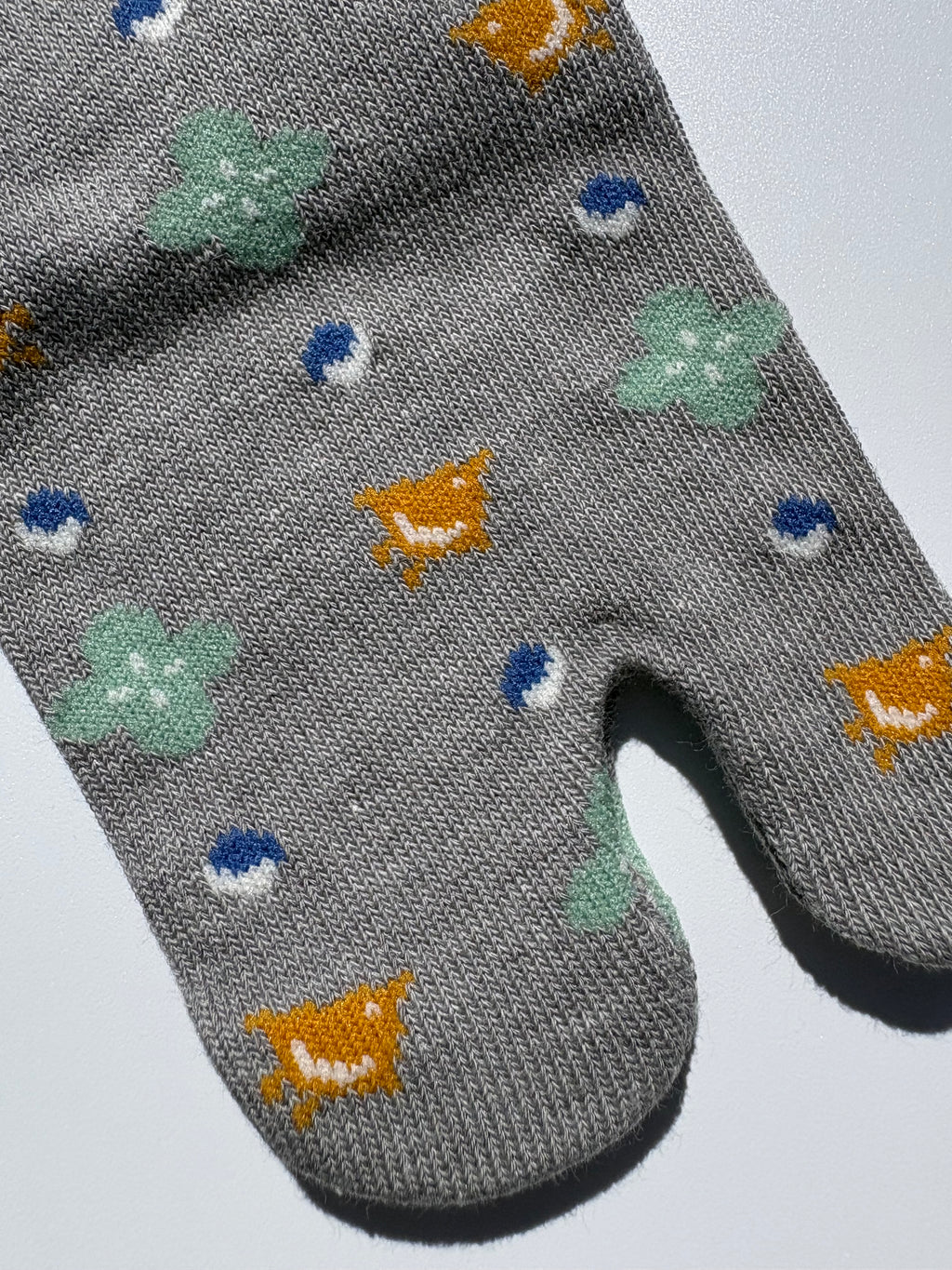 close up of grey bird print tabi socks - japanese split toe design made of cotton - flat lay on white background made in japan