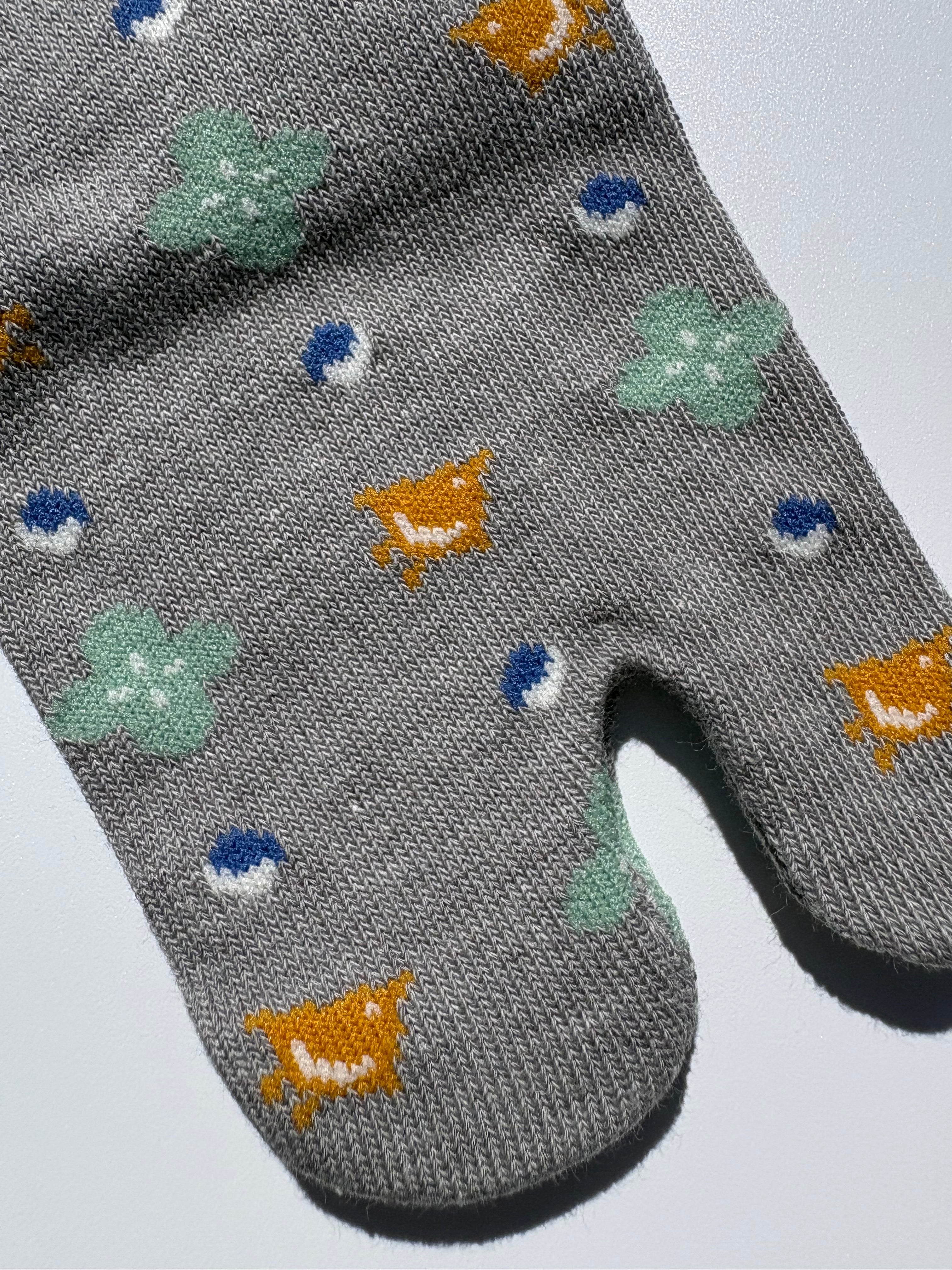 close up of grey bird print tabi socks - japanese split toe design made of cotton - flat lay on white background made in japan