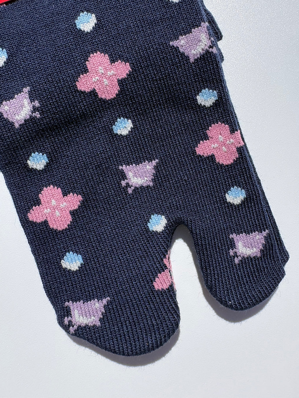 close up of navy bird print tabi socks - japanese split toe design made of cotton - flat lay on white background made in japan