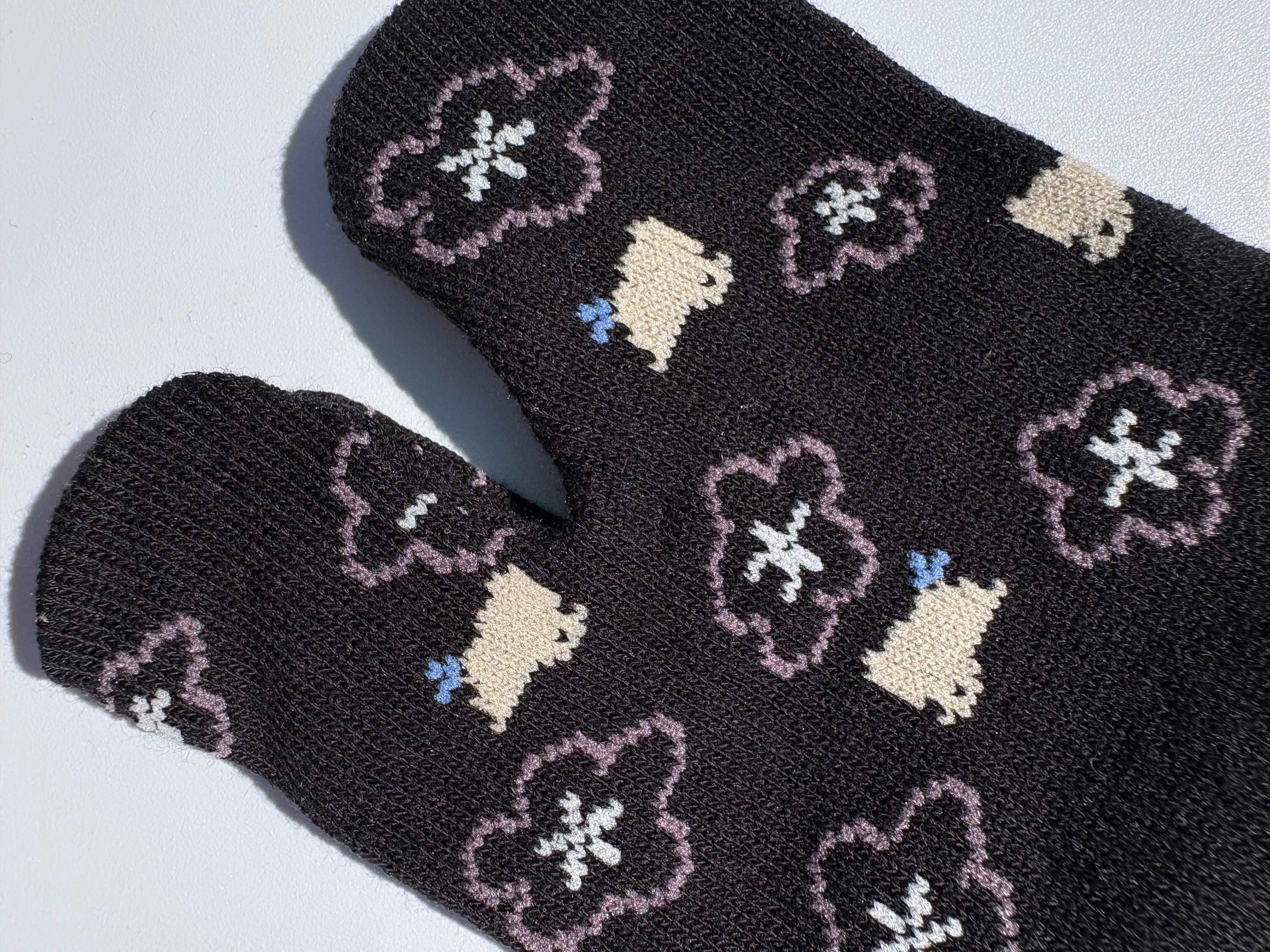 close up of black bird and sukra flower print tabi socks