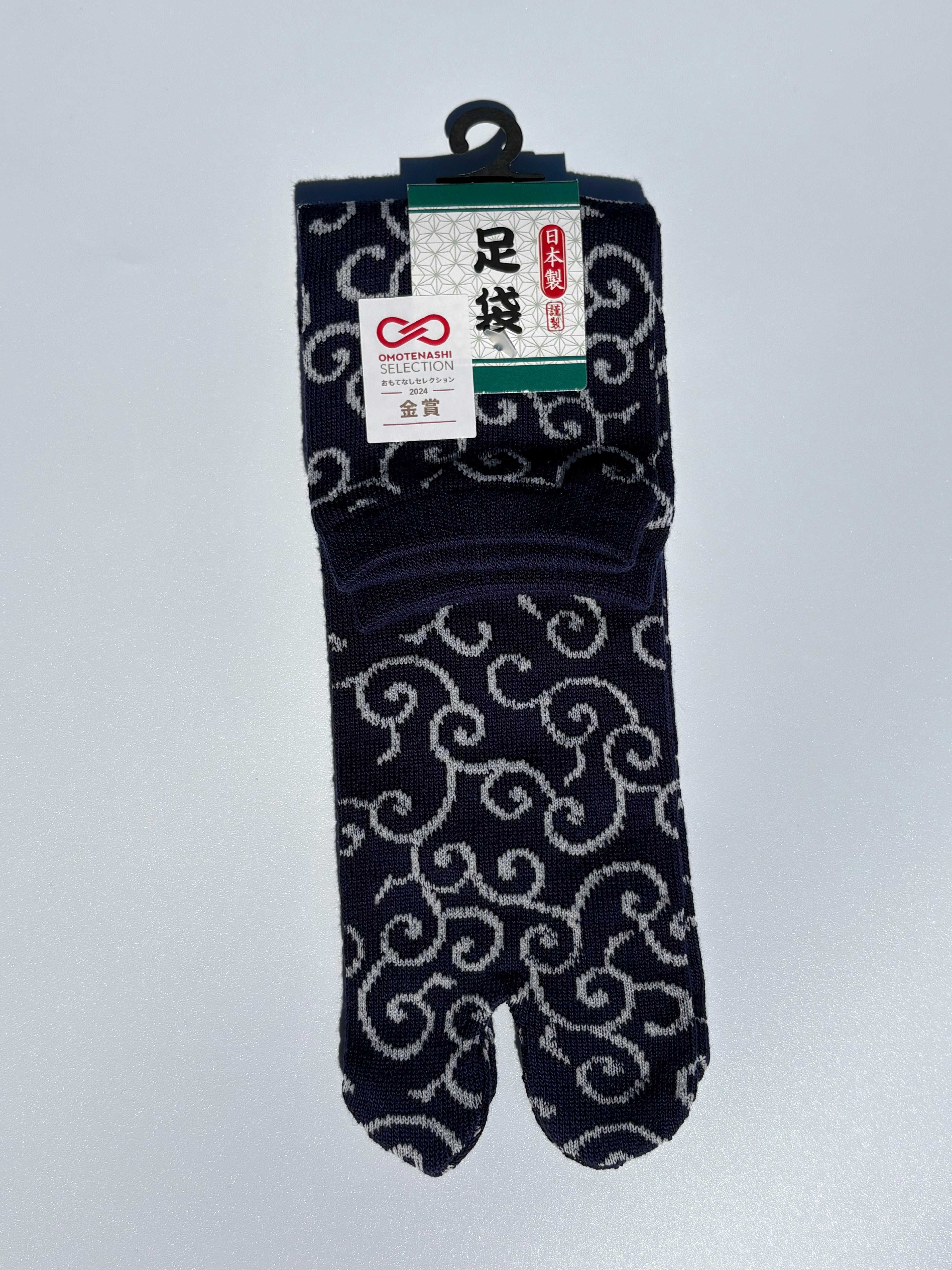 navy tabi split-toe socks with white karakusa arabesque scroll pattern — Omotenashi Selection Gold Award 2024 Japanese-made tabi socks (足袋)