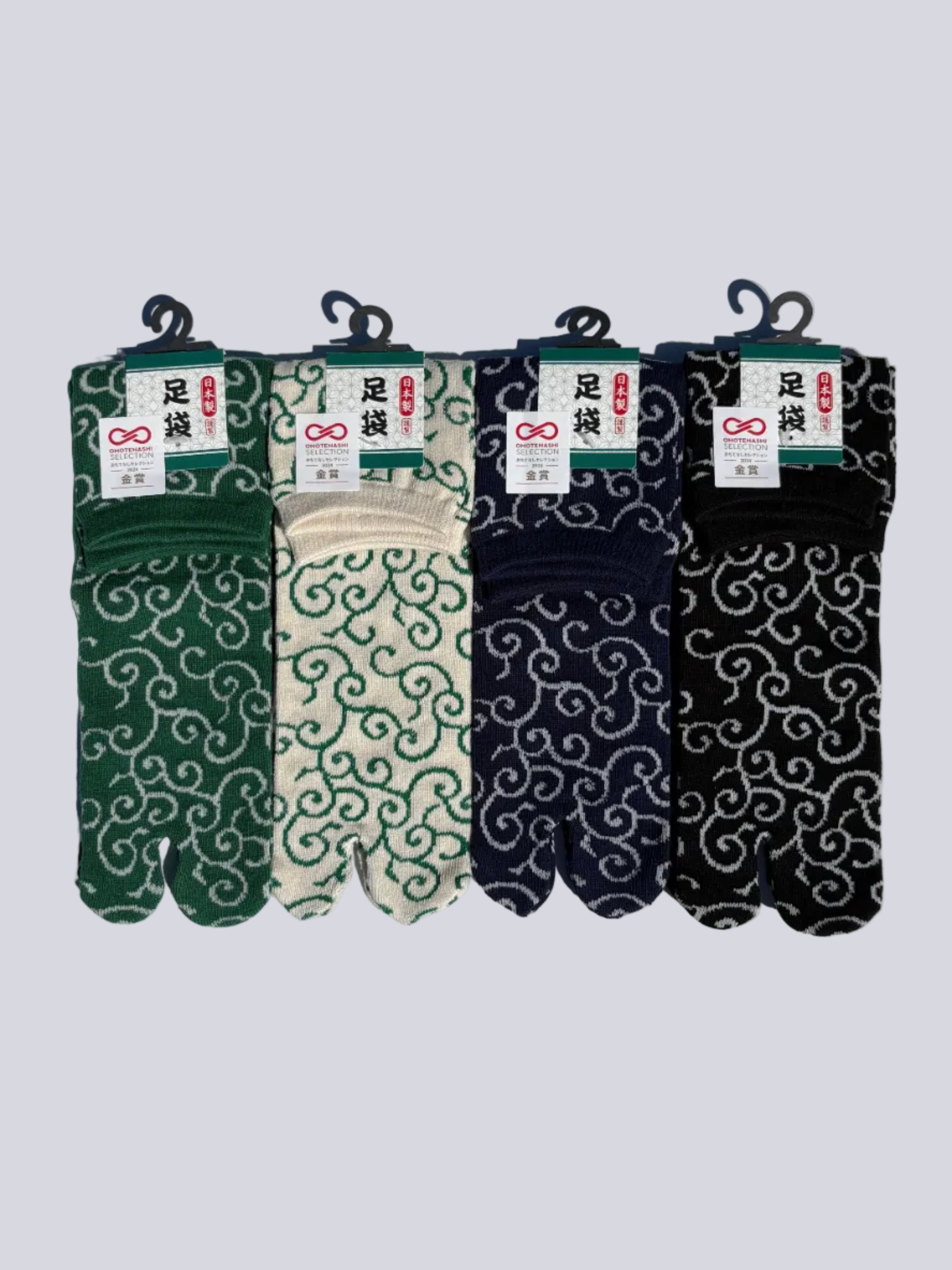 Four pairs of tabi split-toe socks with Japanese karakusa arabesque scroll pattern in black, navy, cream, and forest green — Omotenashi Selection Gold Award made in Japan