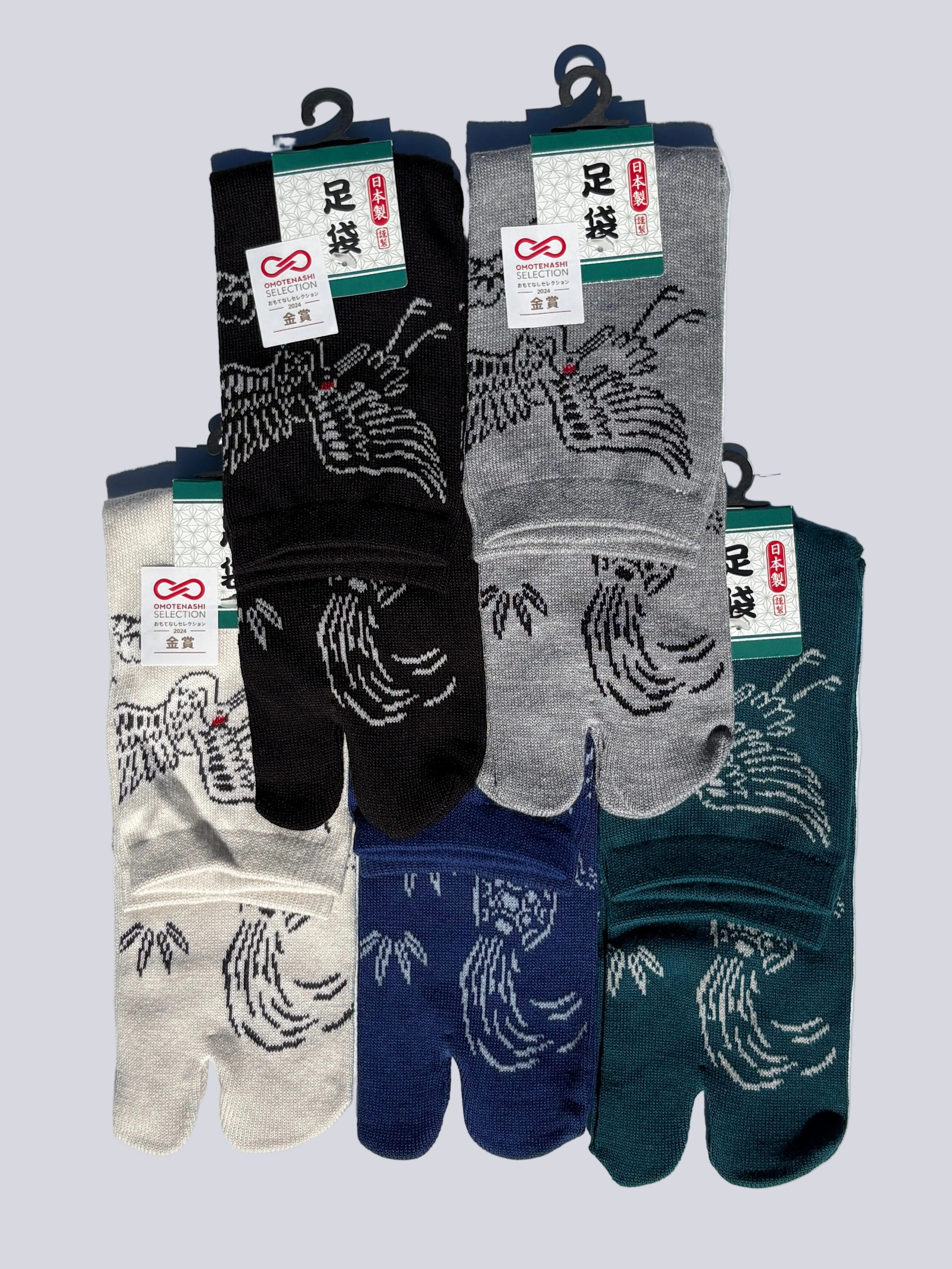 Set of five pairs of tabi socks with different color varieties on a light gray background. Print is of a crane and turtle in japanese graphic - crew length made of cotton