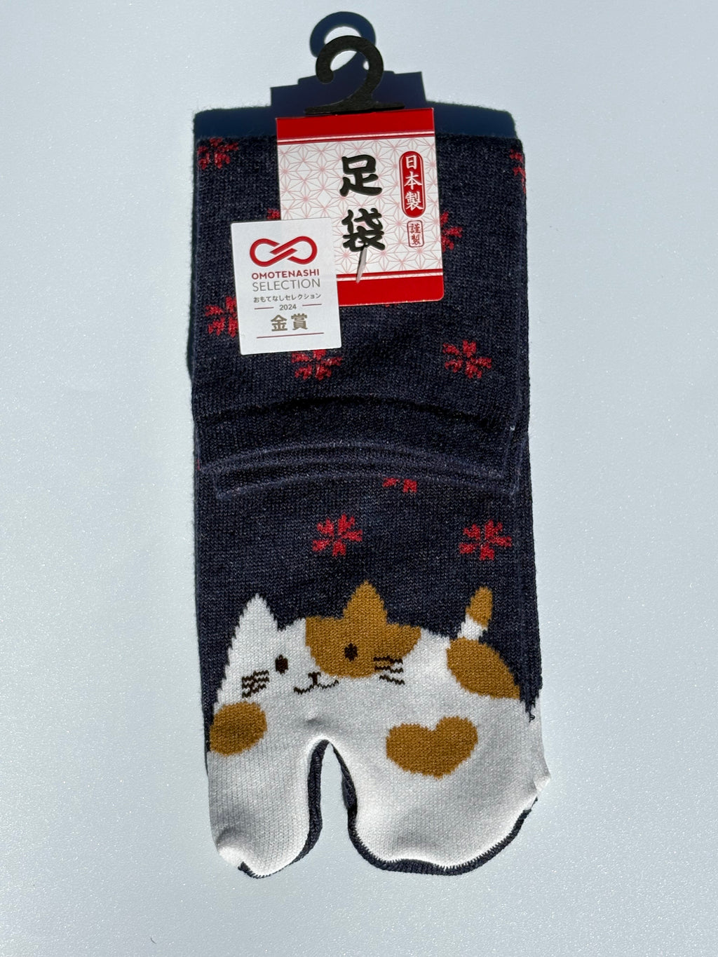 navy tabi split-toe socks with cute kawaii cat face and red snowflake print — Omotenashi Selection Gold Award 2024 Japanese novelty cat tabi socks (足袋)