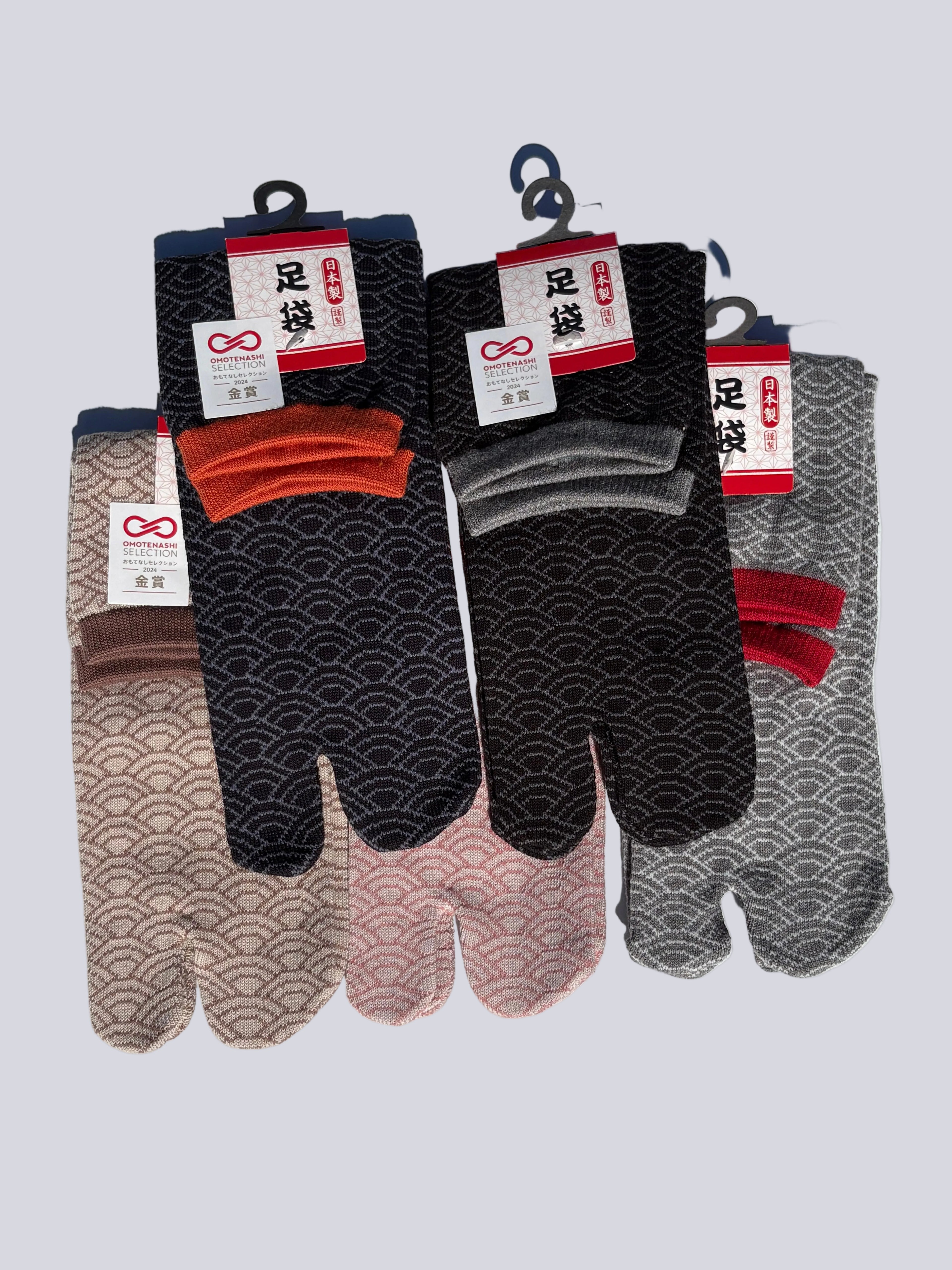 five pairs of tabi split-toe socks in traditional Japanese seigaiha wave pattern — black with rust, black with grey, taupe, pink and grey with red cuff — Omotenashi Selection Gold Award made in Japan