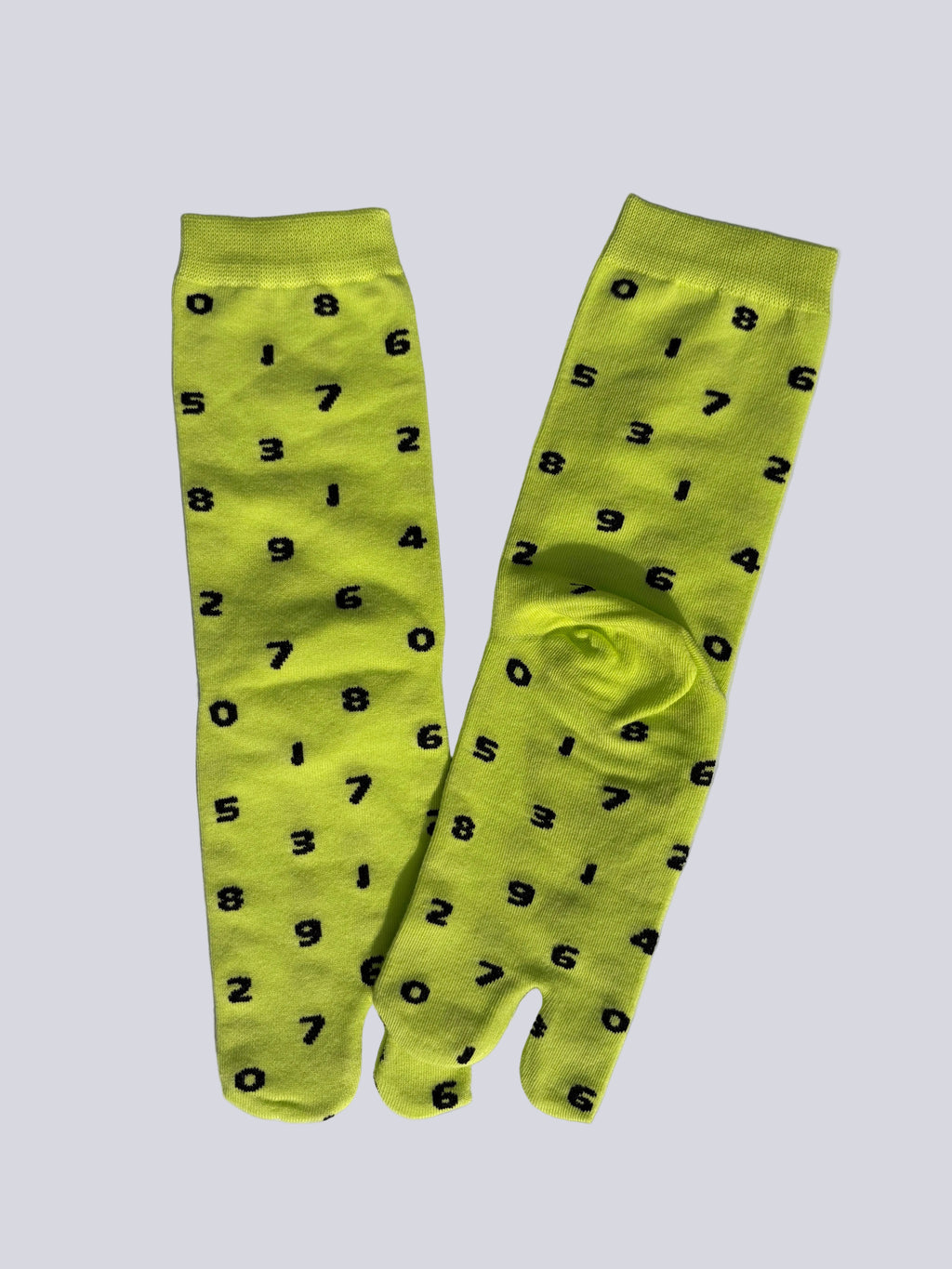 neon yellow tabi socks with black numbers on,, flat lay on white background japanese split toe design