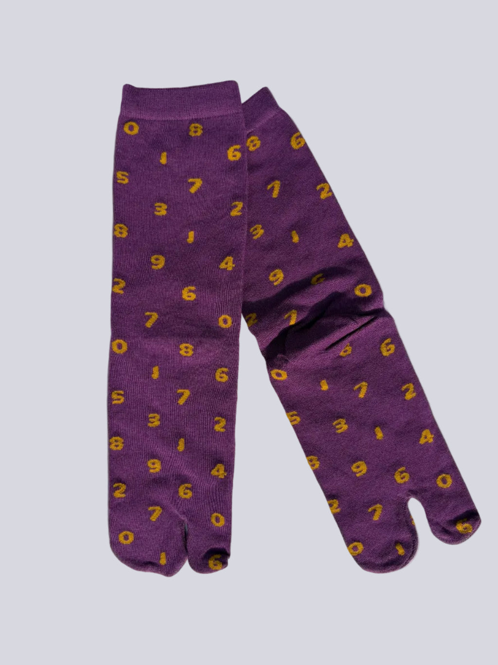 Tabi split-toe socks flat lay— purple with yellow numbers and orange with navy numbers — novelty Japanese split-toe socks made of cotton