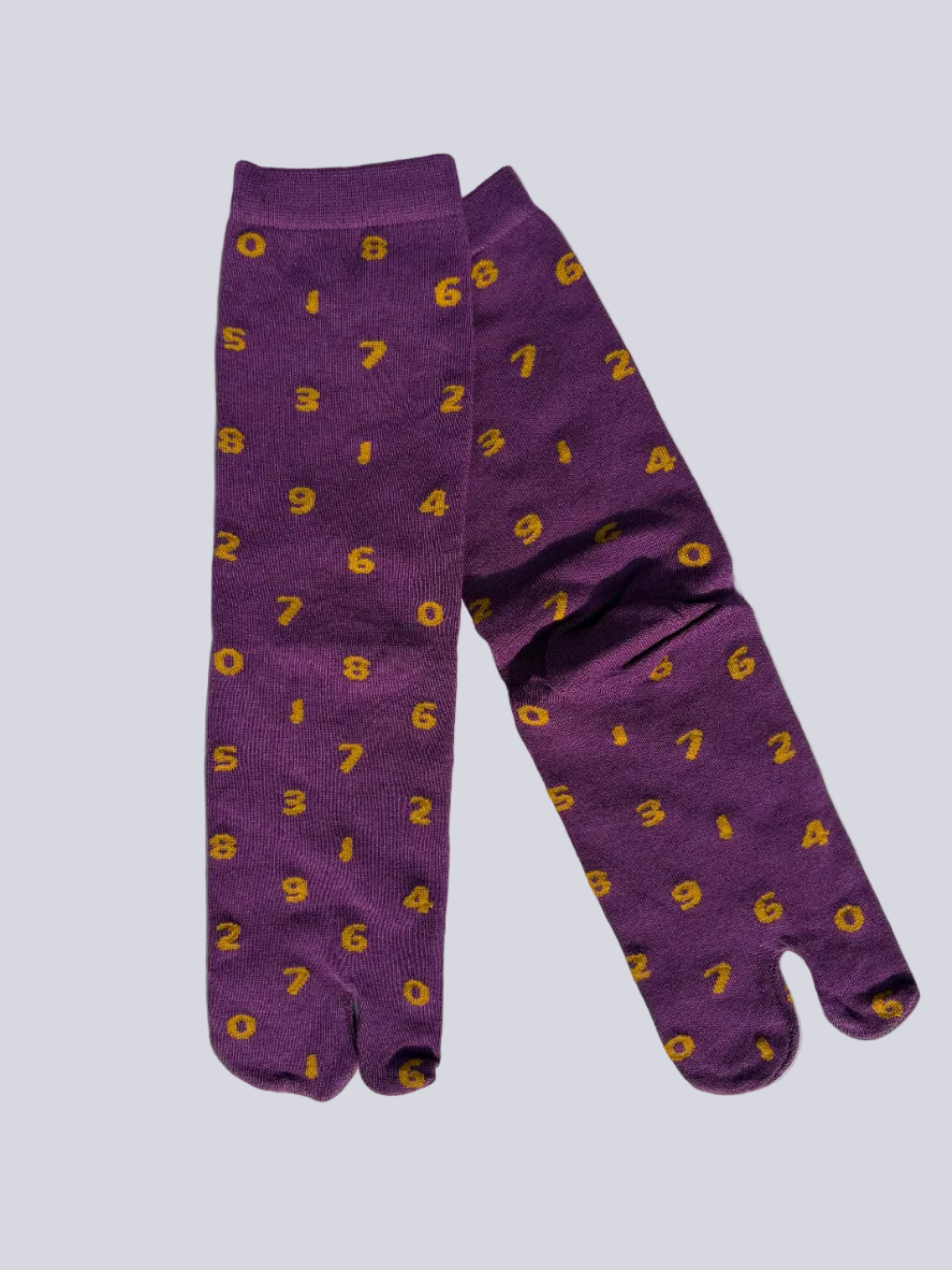 Tabi split-toe socks flat lay— purple with yellow numbers and orange with navy numbers — novelty Japanese split-toe socks made of cotton