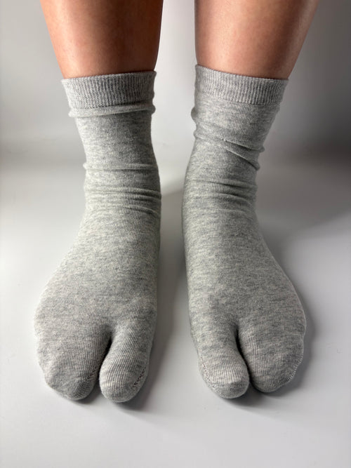 Grey socks worn on a white background