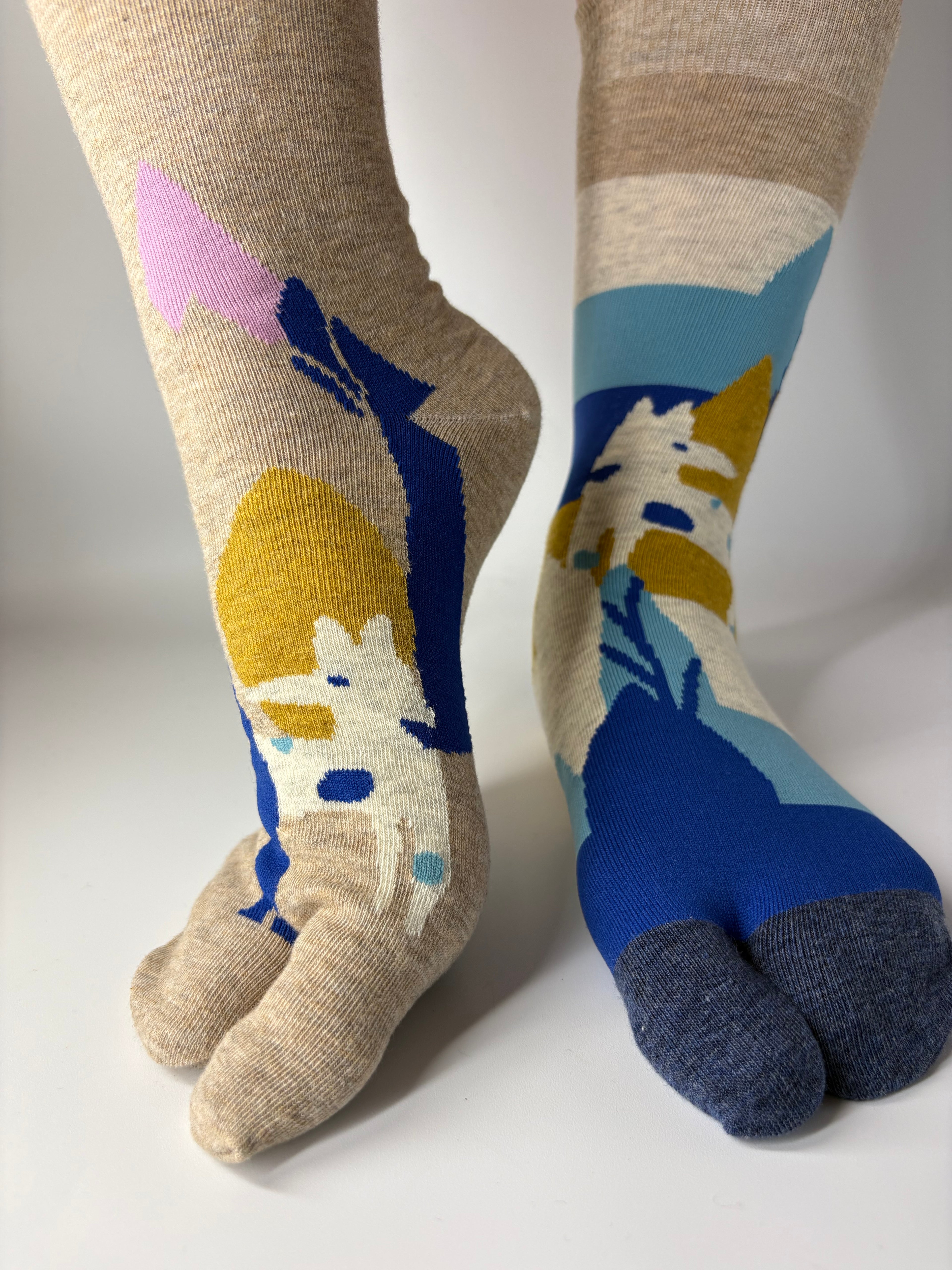 Colorful socks with abstract patterns depicting farm life on a white background