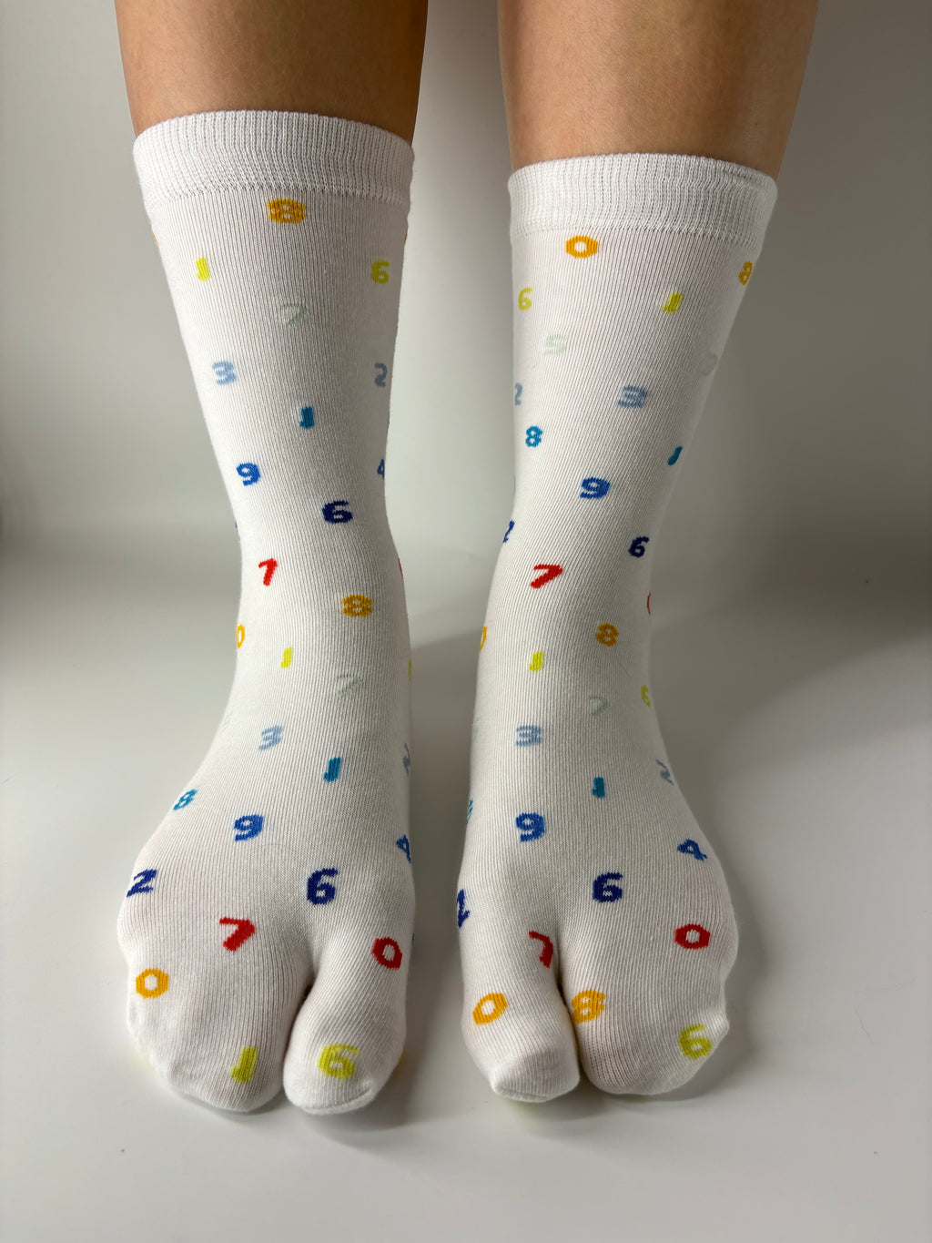 White crew-length tabi socks with a playful all-over multicoloured numbers print