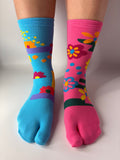 Tabi Co. split-toe cotton socks in sky blue and pink with a bright floral print, worn on feet