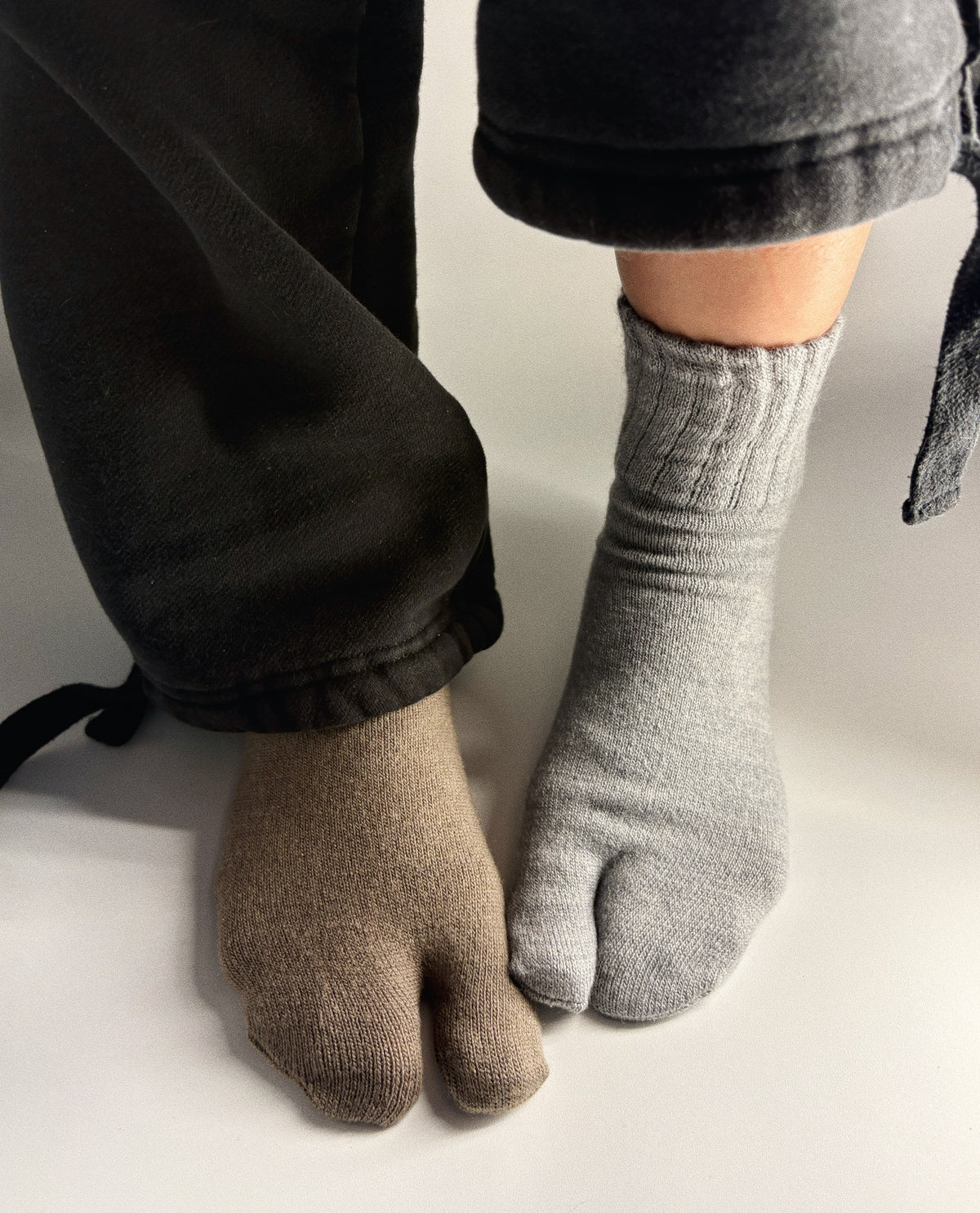 Tabi split-toe socks in grey and taupe worn with black joggers — Japanese wool blend tabi socks for minimalist outfits by Tabi Co.