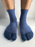 A pair of blue ribbed split-toe tabi socks worn on a person's feet, shown against a plain white background.
