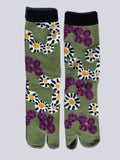 Olive green tabi split-toe socks with bold retro daisy and purple flower print, black cuff — Japanese floral tabi socks in green
