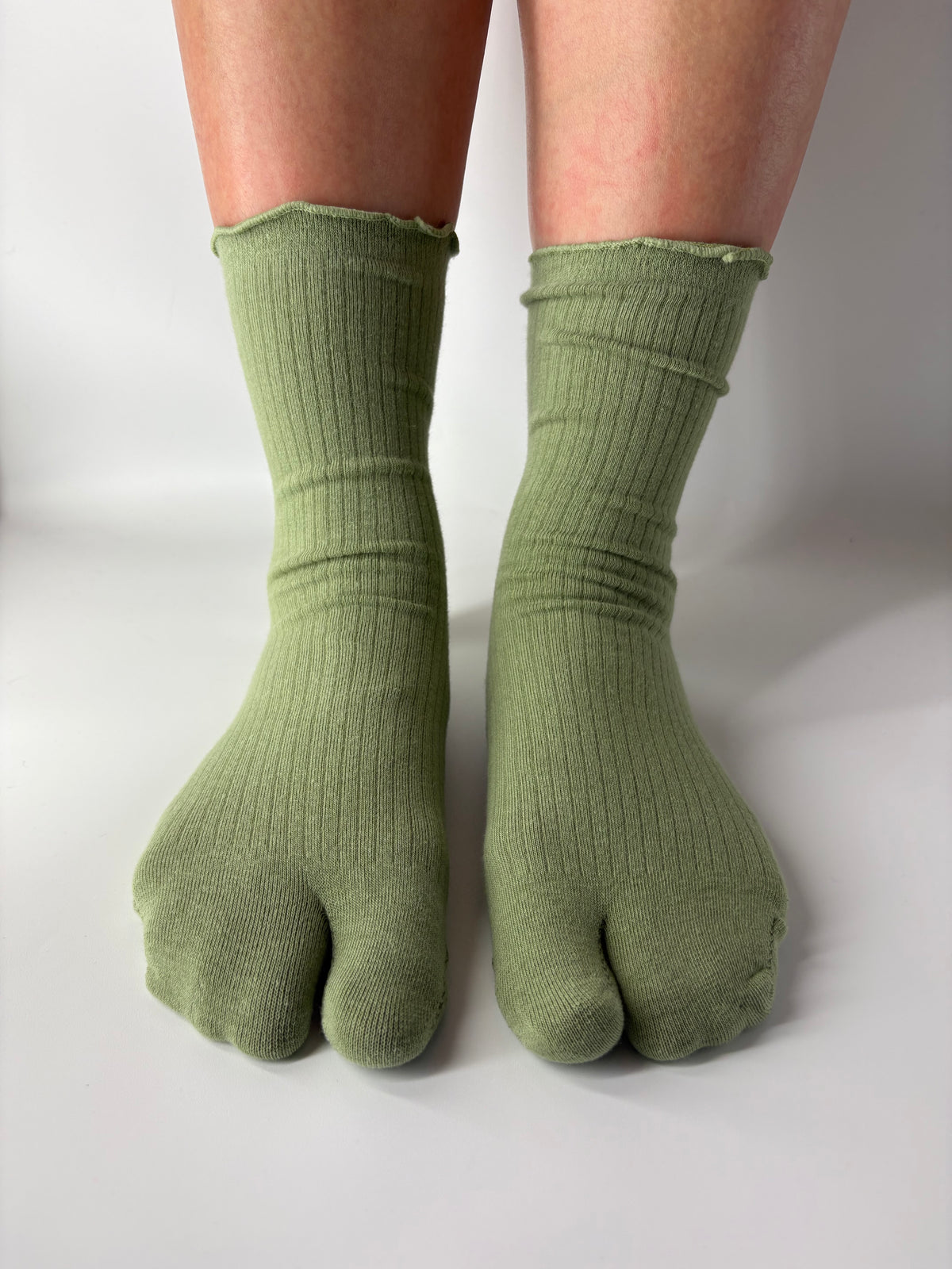 green frilly socks being worn on a person's feet with a light lettuce ruffle edge