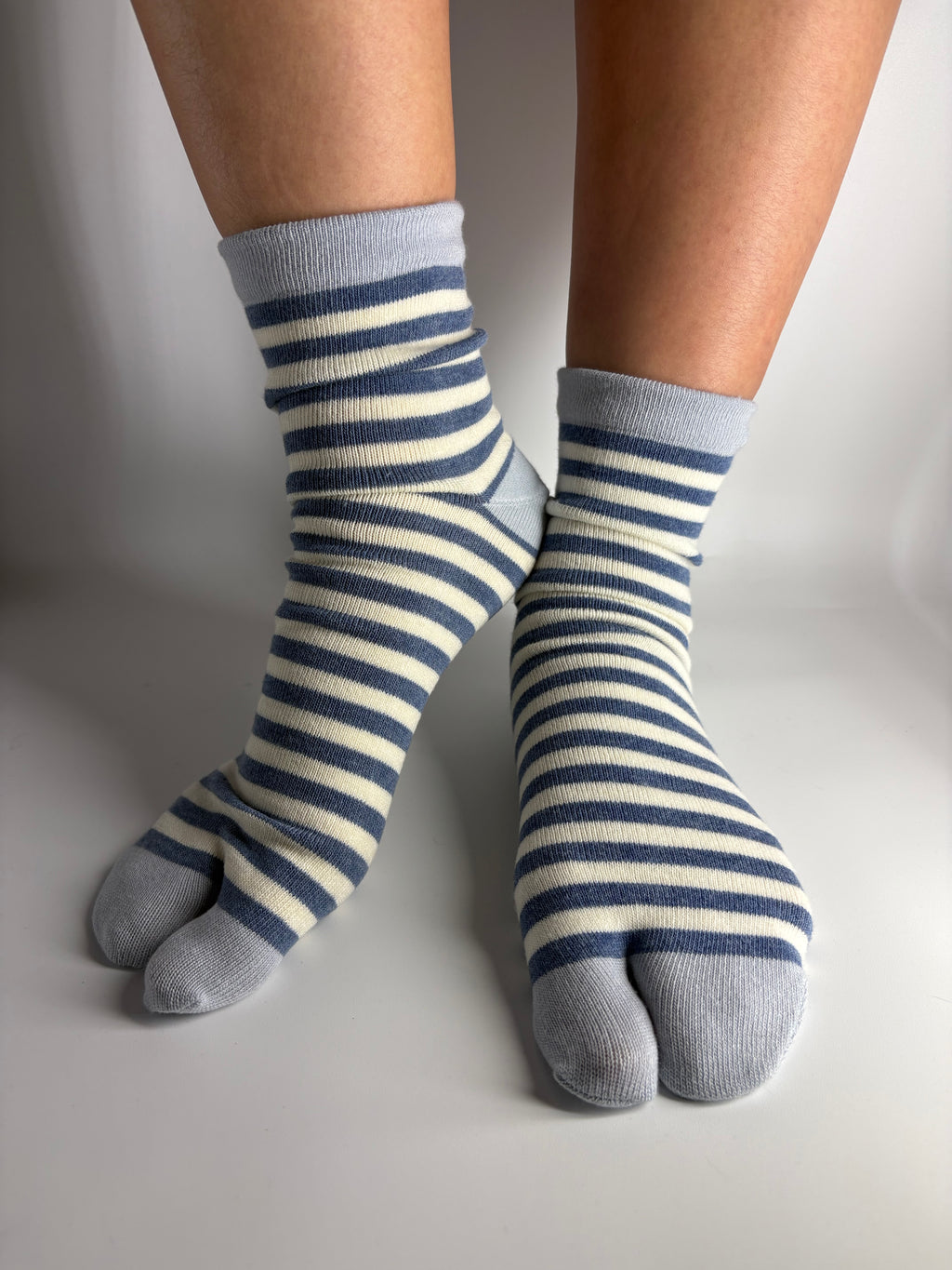 navy striped tabi socks worn on a person's foot