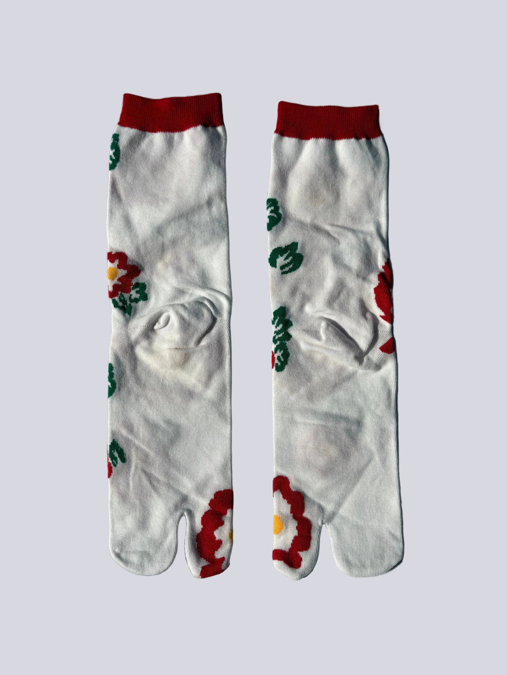 Back of a pair of white socks with floral designs on a white background