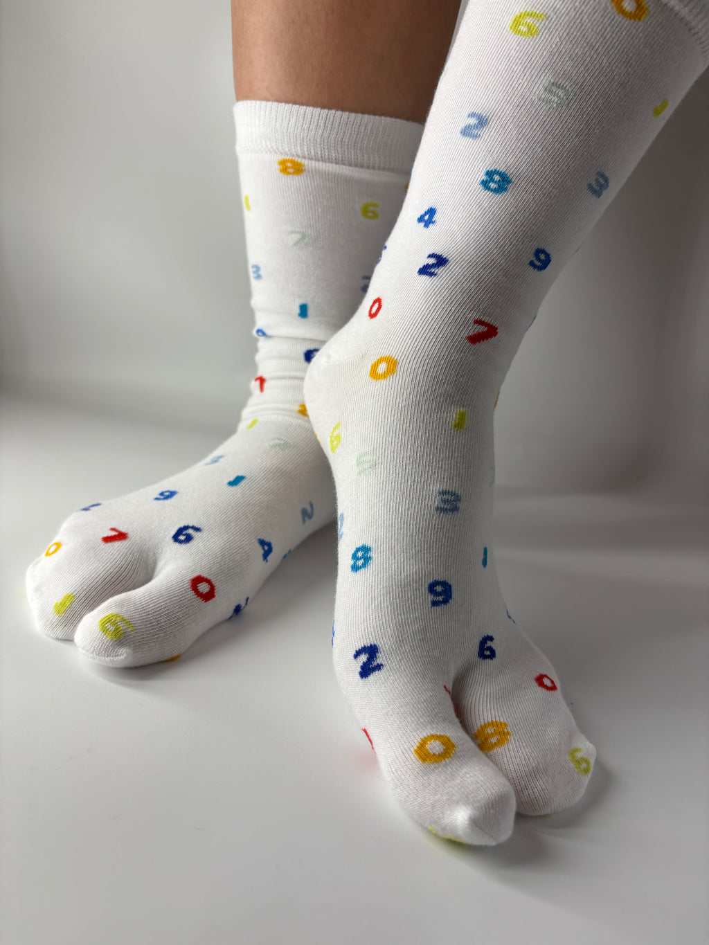 White crew-length tabi socks with a playful all-over multicoloured numbers print